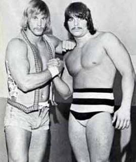 Wrestlers Randy Savage and Lanny Poffo joining hands to show unity and strength