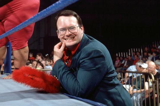 Him Cornette smiling as he stands at the side of the ring