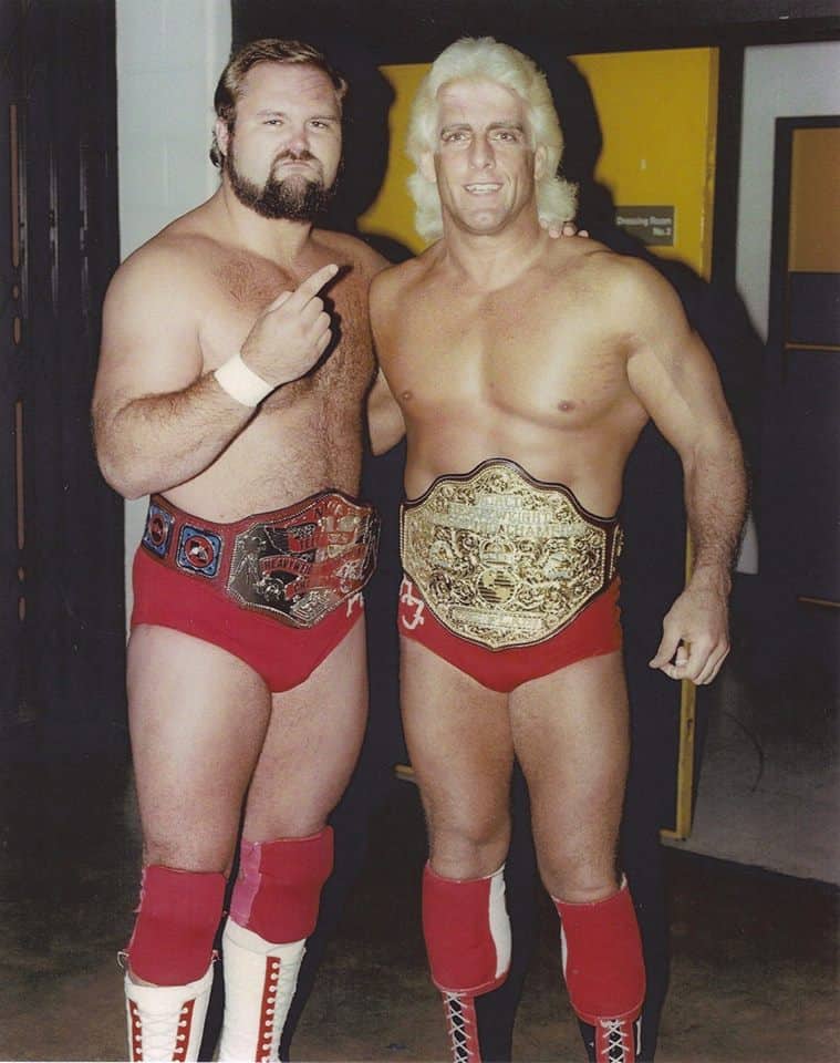 Arn Anderson pointing at Flair with #1 sign both wearing title belts