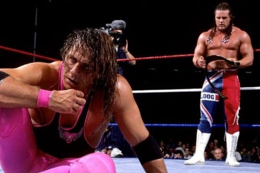Bret Hart looking defeated as the British Bulldog holds the intercontinental title belt at the end of SummerSlam 1992