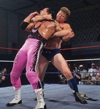 Bob Backlund with his arm around Bret's neck and his left arm locked during a match