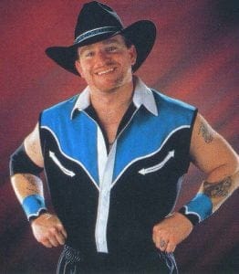 Brian James in the mid-1990s dressed in a cowboy hat and blue and black cowboy shirt with the sleeves cut out