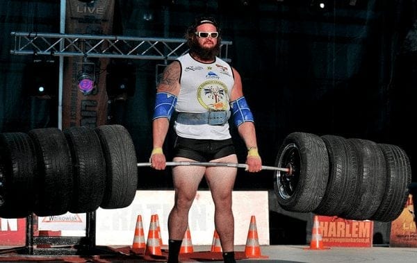 Wrestlers Outside the Ring Braun Strowman's as a Strongman holding 8 weighted tires on a barbell