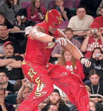 Rey Mysterio as The Flash. Rey wore red trousers and a vest, although the shade were slightly brighter and more in tune with that of the Scarlett Speedster. His side 