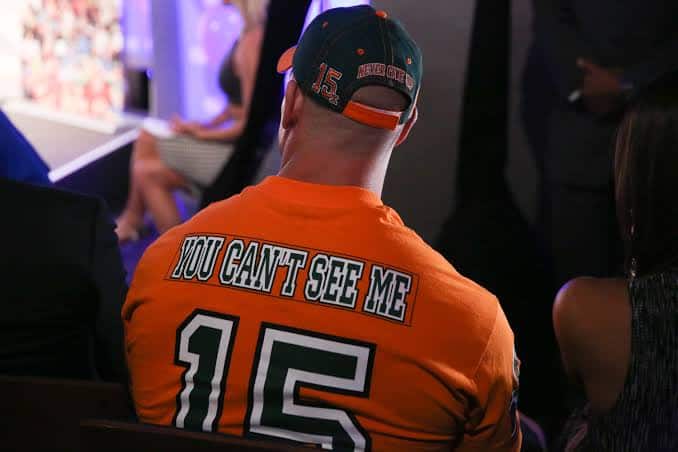 John Cena donning an orange shirt with the catchphrase you can't see me on the back.