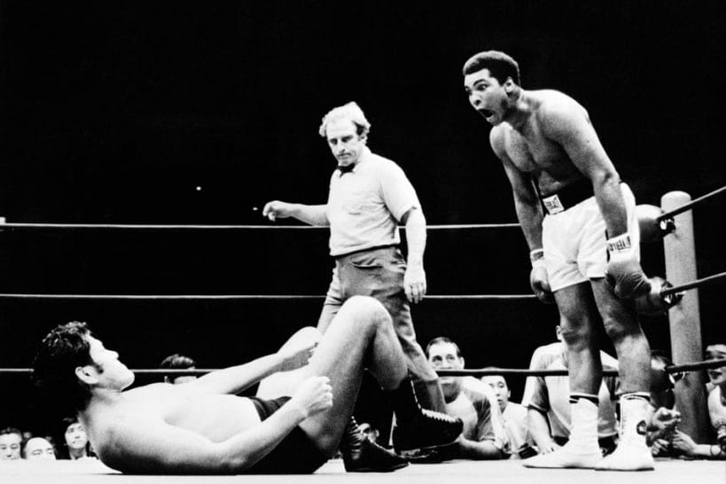 If Muhammad Ali expected a worked exhibition, he was probably not pleased with the repeated kicks to his legs he took by Antonio Inoki. Ali is seen here taunting Inoki as referee Gene LeBell looks on.