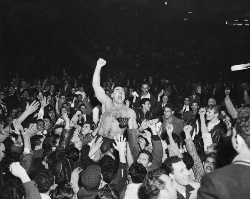 A fuller view of Antonino Rocca being hoisted on the shoulders of his followers shortly before police restored order at the Madison Square Garden riot on November 19th, 1957. [Photo: Walter Kelleher/NY Daily News Archive]