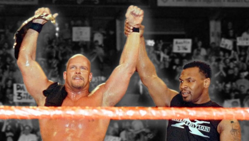 Iron Mike Tyson raises Stone Cold Steve Austin's hand in victory after winning his first WWF Championship at WrestleMania 14 in 1998.